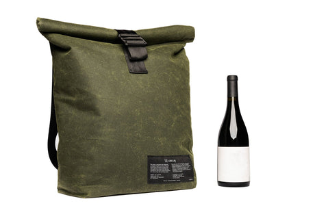 Sac isotherme en coton ciré vert olive à rabat roulé et boucle de cuir, isolé à l'asclépiade, présenté avec une bouteille de vin, isolation faite au Québec.