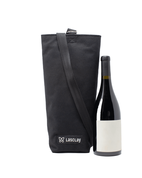 Sac à bouteille de vin isotherme noir Lasclay en toile de coton doublée de polyester présenté à côté d'une bouteille, bandoulière et logo brodé, isolant à la soie du Québec.