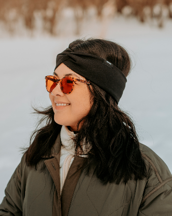 Femme portant un bandeau torsadé noir Lasclay isolé à l’asclépiade – accessoire chaud et stylé pour l’hiver.