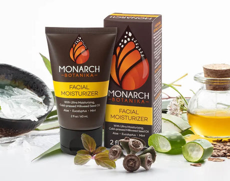 Monarch Botanika facial moisturizer tube and box with milkweed seed oil, aloe and fresh milkweed sprigs