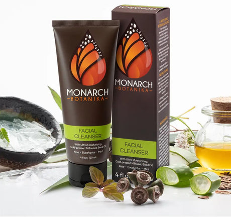 Monarch Botanika facial cleanser tube and box with cold-pressed milkweed seed oil, aloe, eucalyptus and mint, surrounded by botanical ingredients